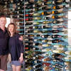 Owners Mike & Marty standing in front of a wall of wine bottles
